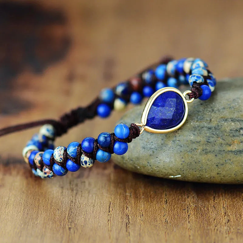 Blue beaded bracelet with a large blue stone on a wooden surface