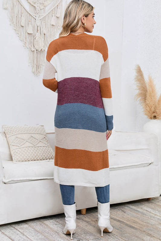 Woman wearing a long, colorful striped dress in a living room setting.