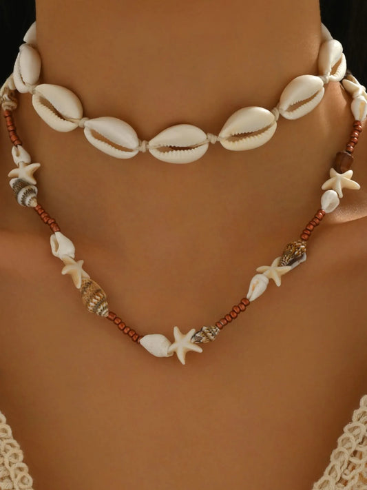 Necklace with shell and starfish beads on a person's neck against a neutral background