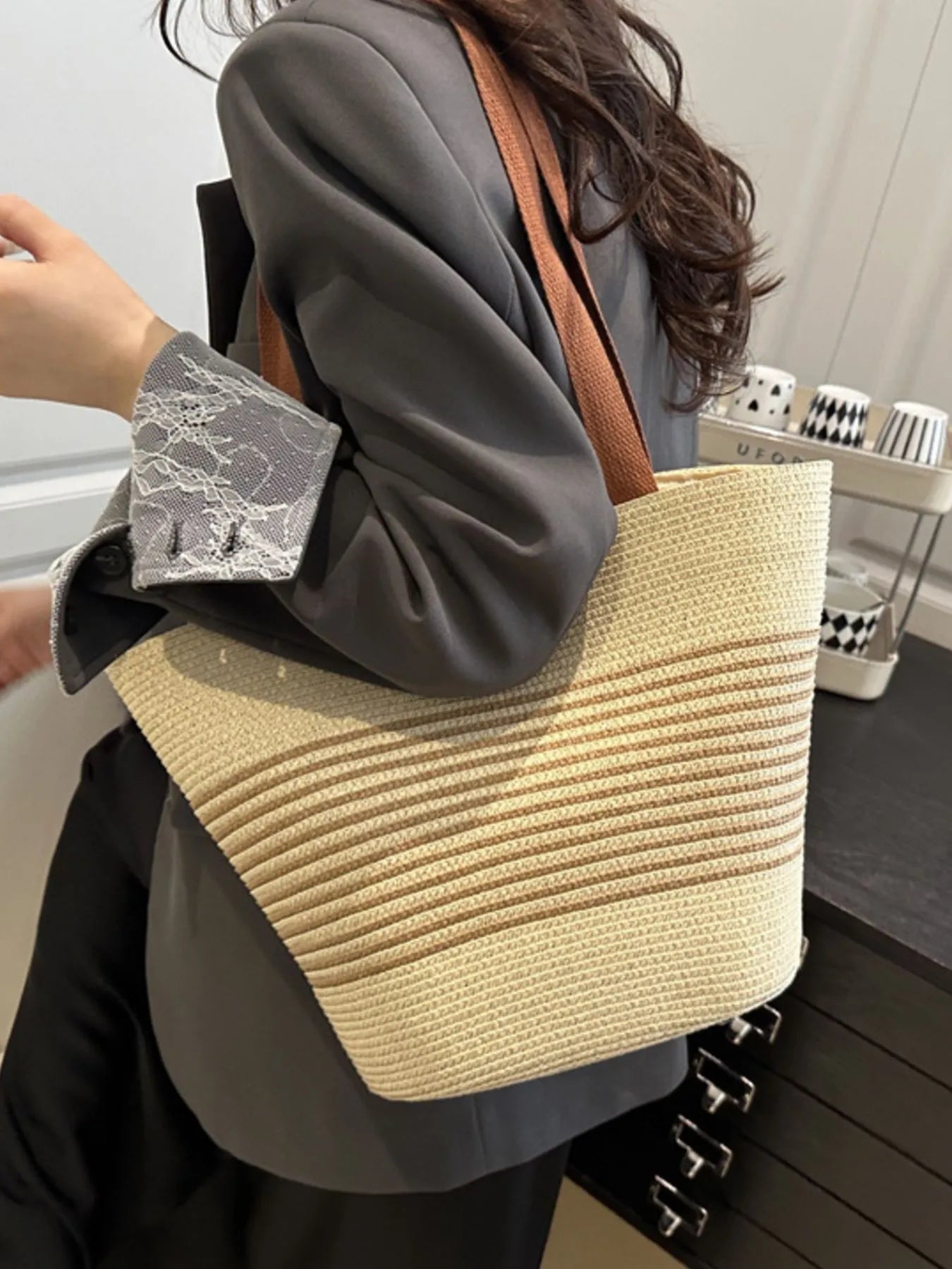 Person holding a straw bag with a neutral background