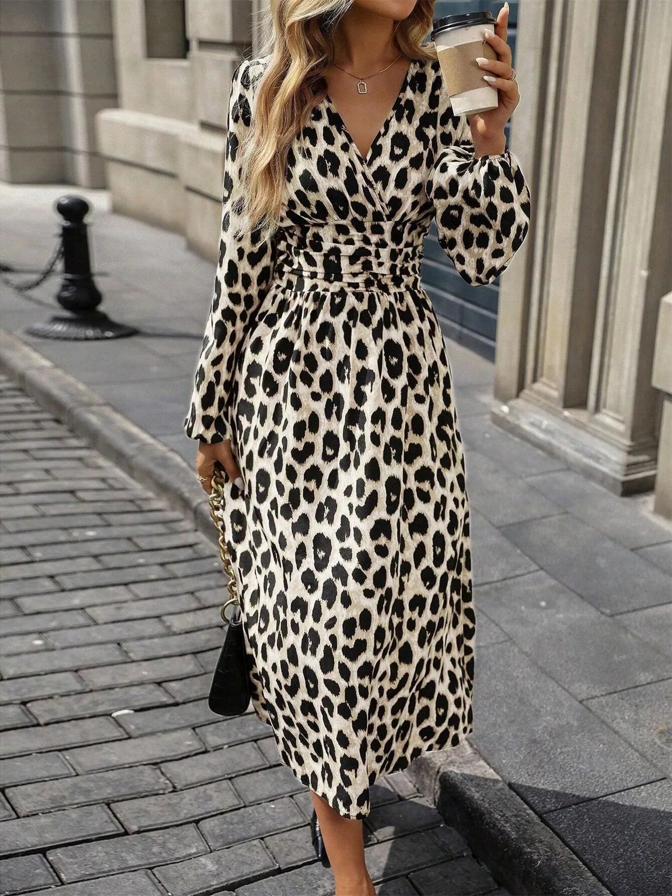 Woman wearing a leopard print dress on a city street.