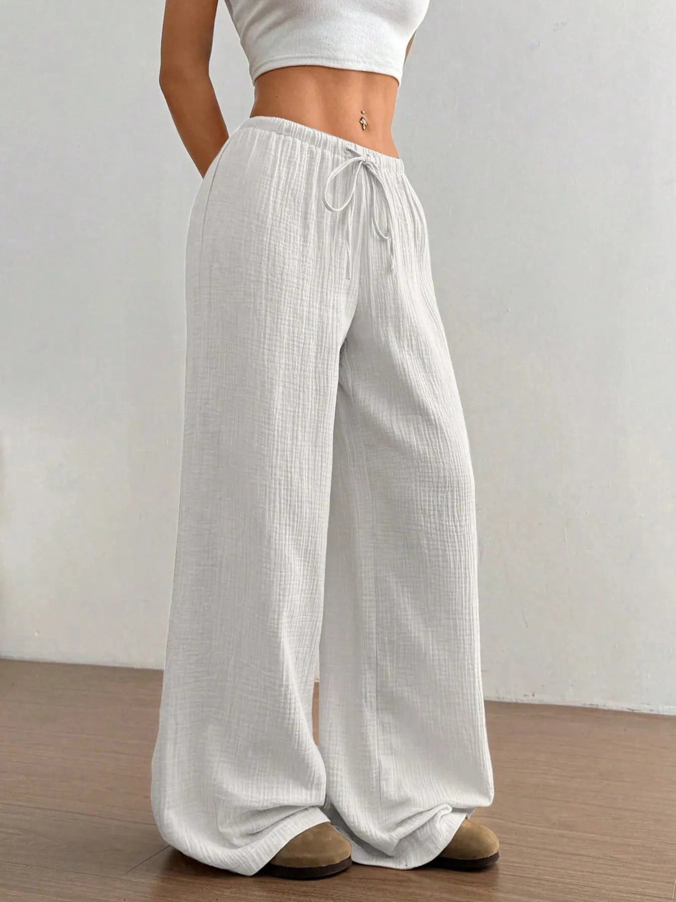 White wide-leg pants worn by a person on a plain background