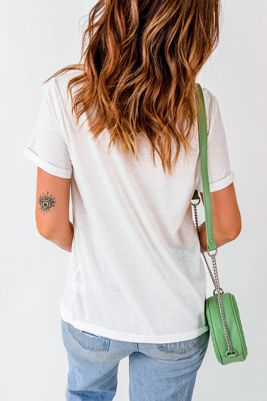 Person wearing a white t-shirt and blue jeans with a green handbag on a plain background