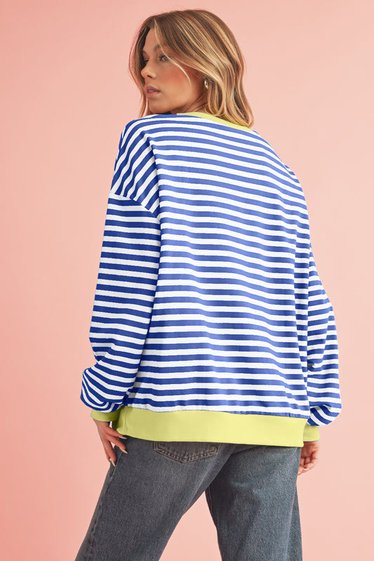 Person wearing a blue and white striped sweater with a pink background