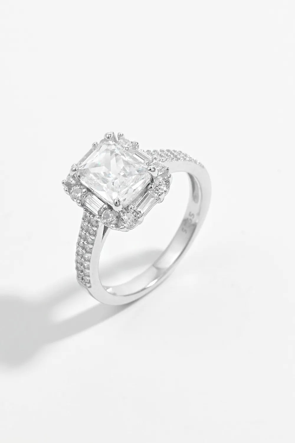 Diamond ring with a rectangular center stone on a white background