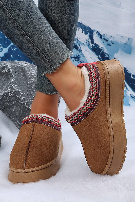 Brown slippers with decorative trim worn in the snow