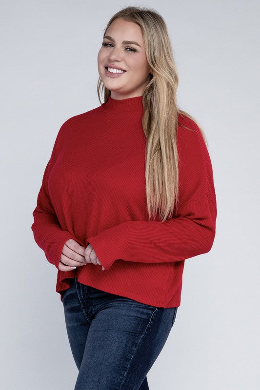 Woman wearing a red sweater and blue jeans against a white background