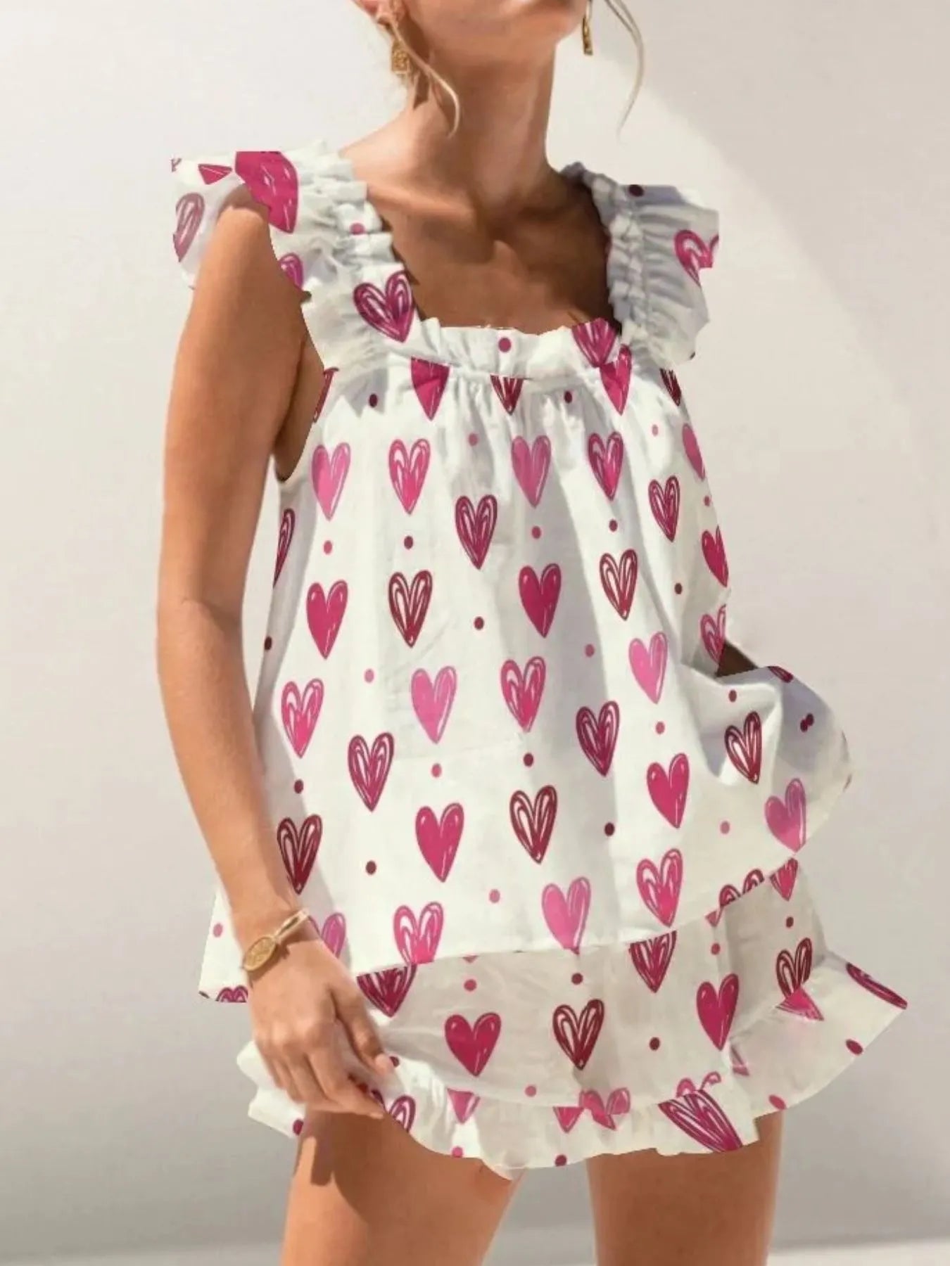 White dress with pink heart patterns on a plain background