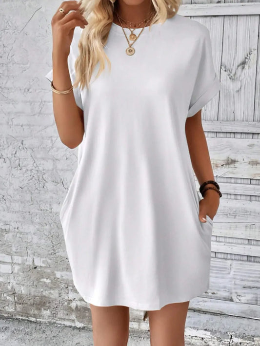 Woman wearing a white dress against a textured wall background