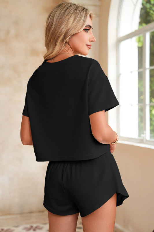 Woman wearing a black outfit standing in a room with a window in the background