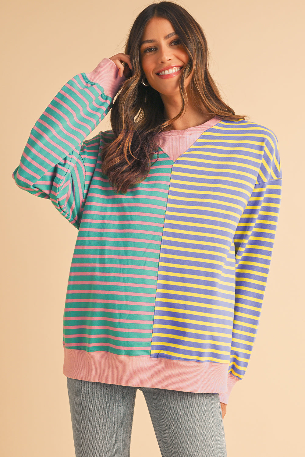 Woman wearing a colorful striped sweater on a beige background