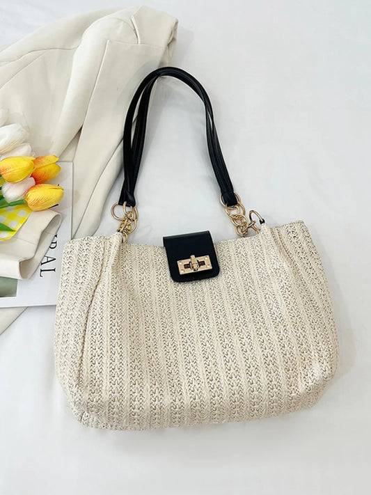 Beige woven handbag with black handle and clasp on a light background