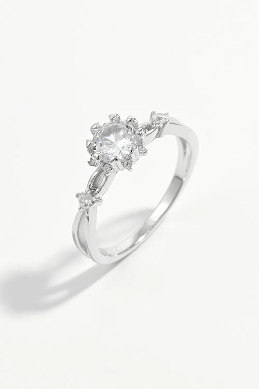 Silver ring with clear gemstones on a white background