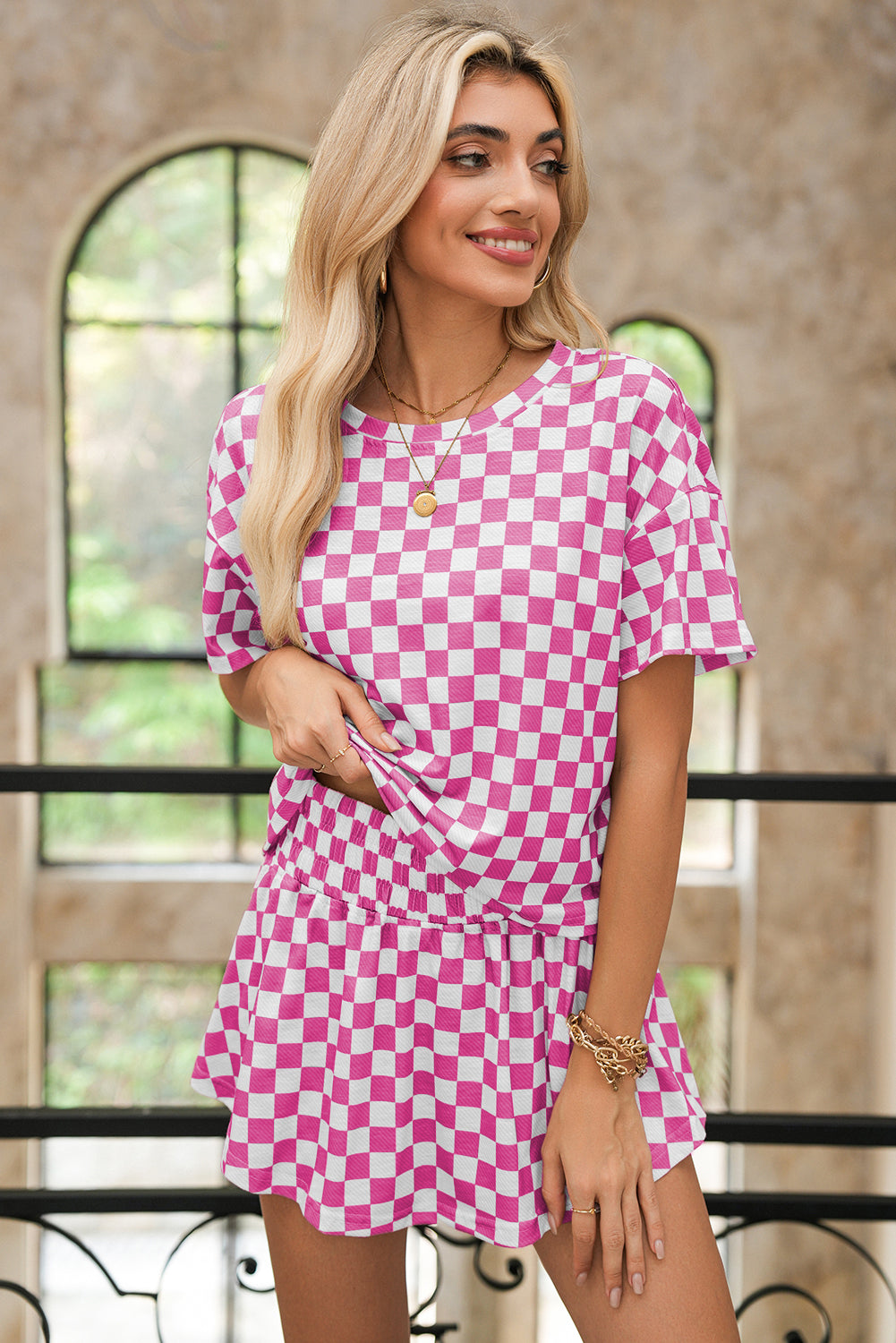 Woman wearing a pink and white checkered dress indoors.