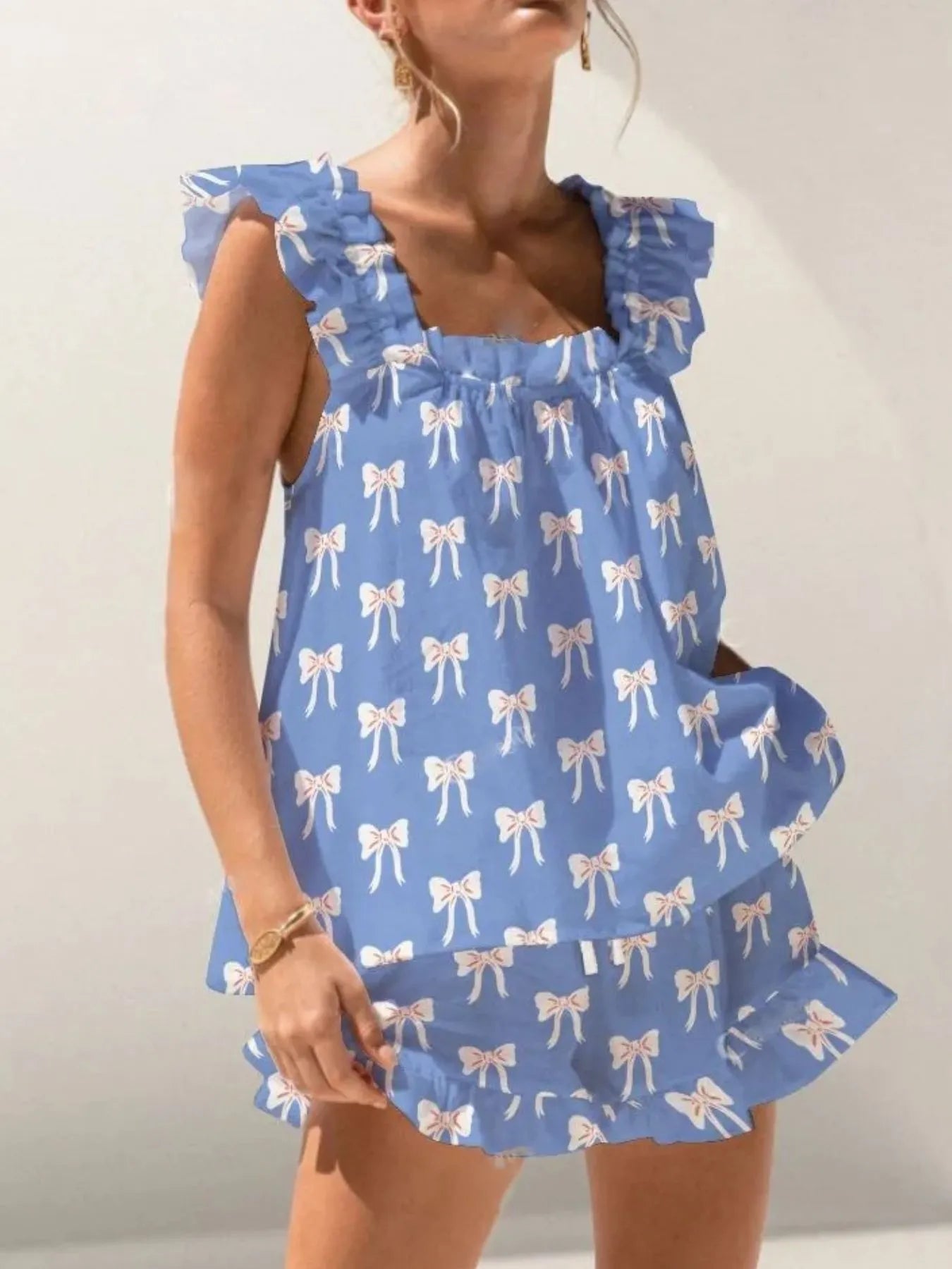 Woman wearing a blue dress with white bow pattern against a plain background