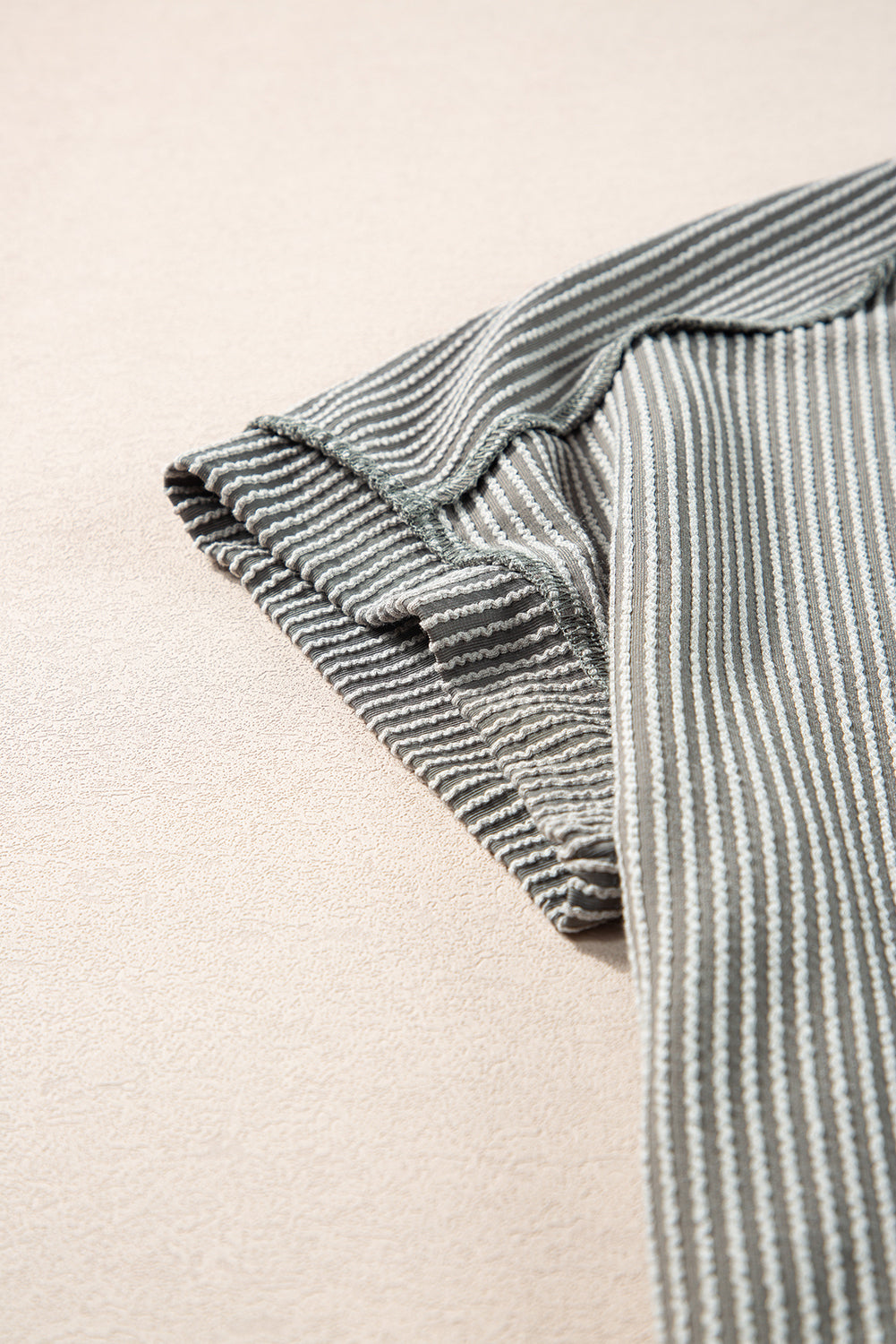Close-up of a striped fabric with a beige background