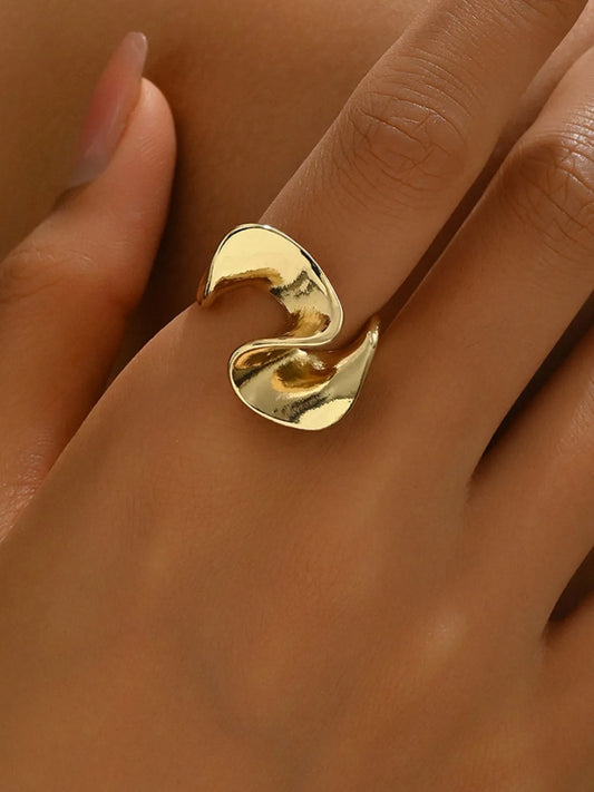 Gold ring on a finger against a neutral background