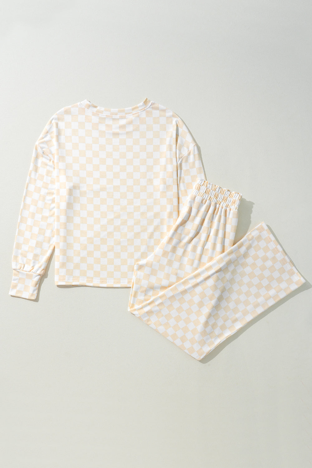White pajama set with yellow pattern on a light gray background