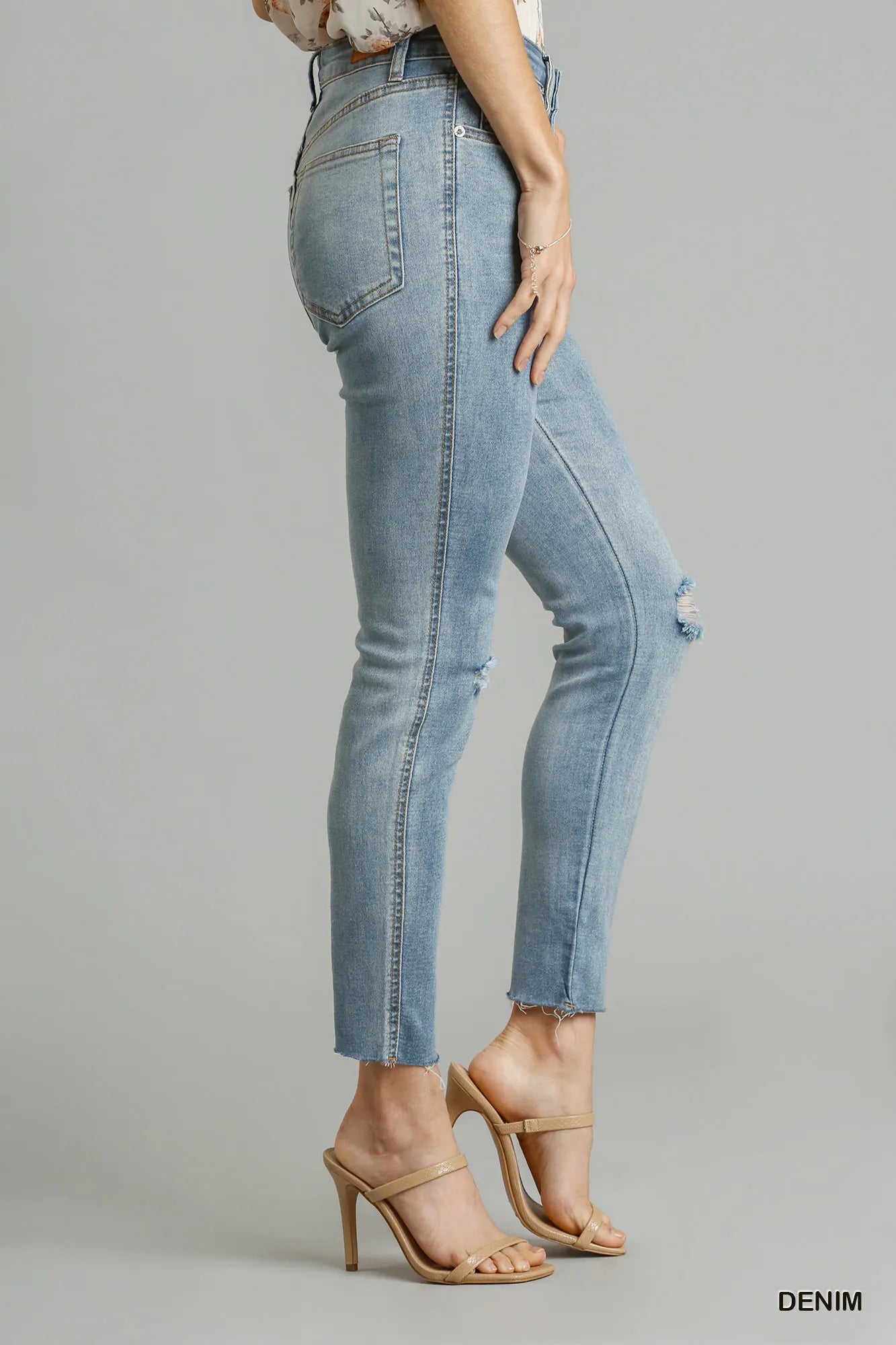 Denim jeans worn by a person on a gray background