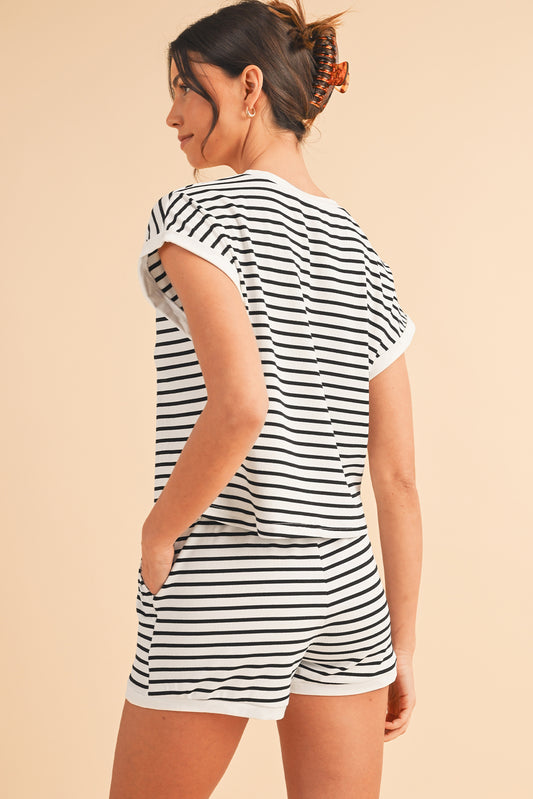 Woman wearing a black and white striped romper on a beige background