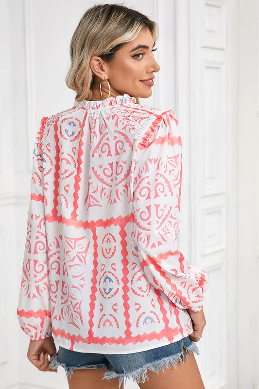 Woman wearing a pink and white patterned blouse against a white background