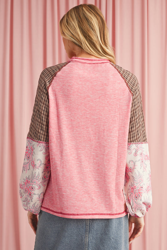Person wearing a pink quilted jacket with floral cuffs against a pink curtain background