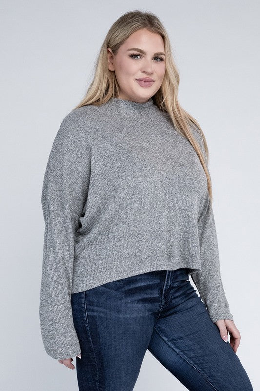Woman wearing a gray sweater and blue jeans on a white background