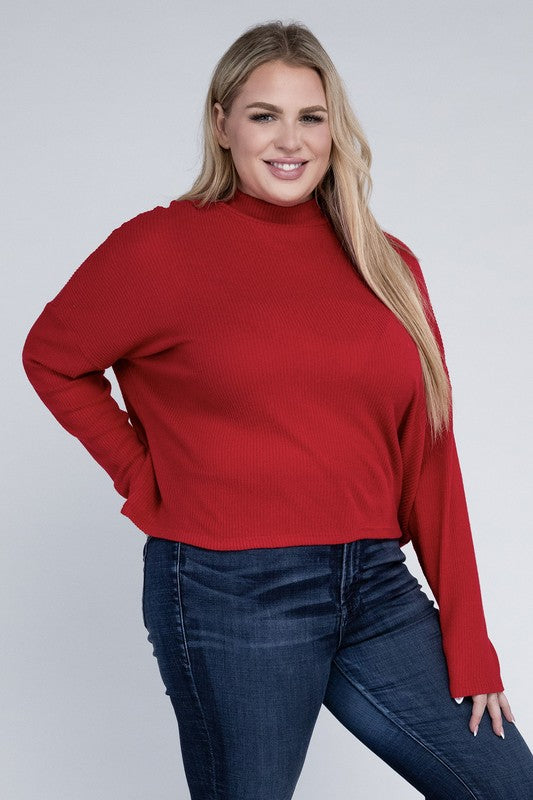 Woman wearing a red sweater and blue jeans against a white background