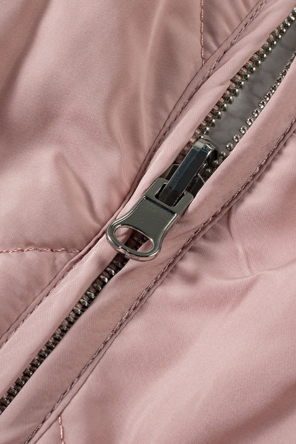Close-up of a pink quilted jacket with a zipper